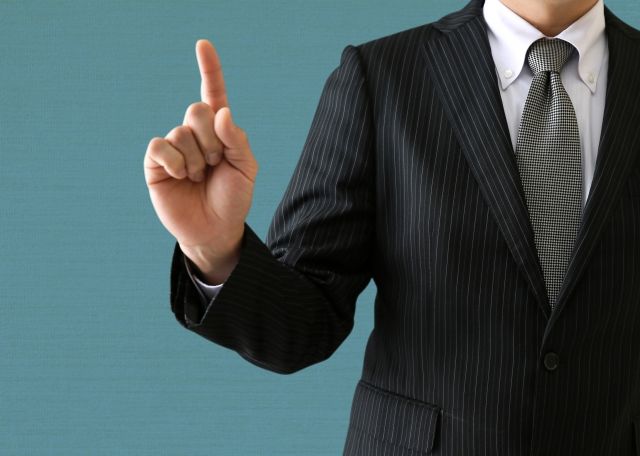 失敗しない業者の選び方について説明するスーツの男性