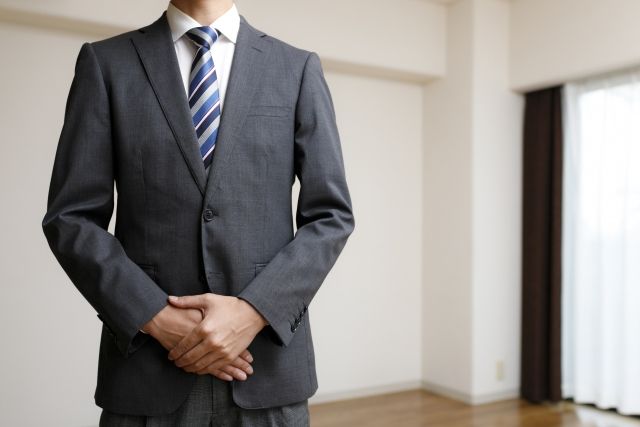 部屋でリフォームの案内するスーツの男性